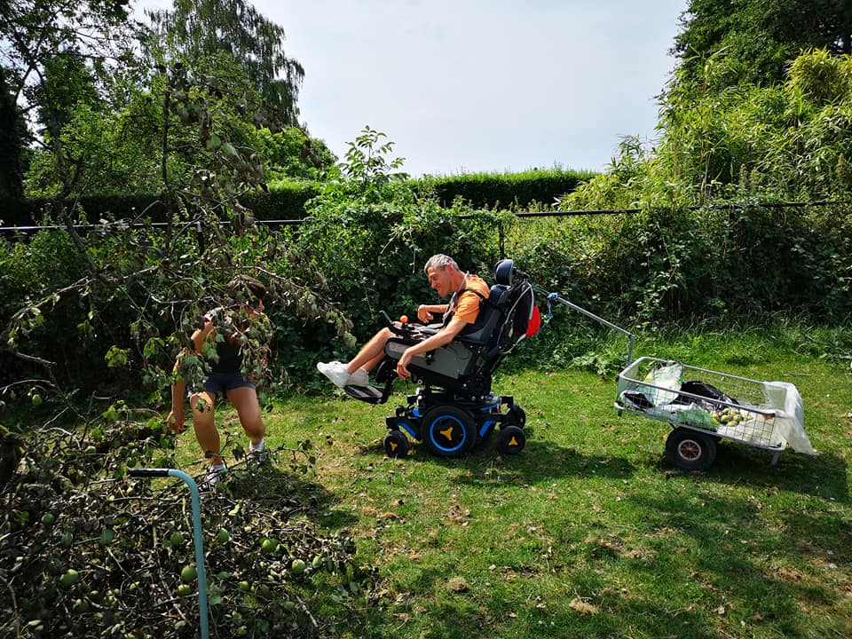 Espace extérieur avec une personne en chaise électrique qui conduit une remorque